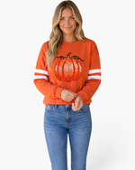 Beach Rose Co. orange sweatshirt with a sequin pumpkin graphic and white varsity stripes on the long sleeves.
