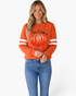 Beach Rose Co. orange sweatshirt with a sequin pumpkin graphic and white varsity stripes on the long sleeves.