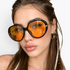 Beach Rose Co. oversized butterfly sunglasses with black frames and amber-tinted lenses on a woman