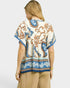 Beach Rose Co. ivory and blue paisley border print rayon top with tassel details and flutter sleeves.