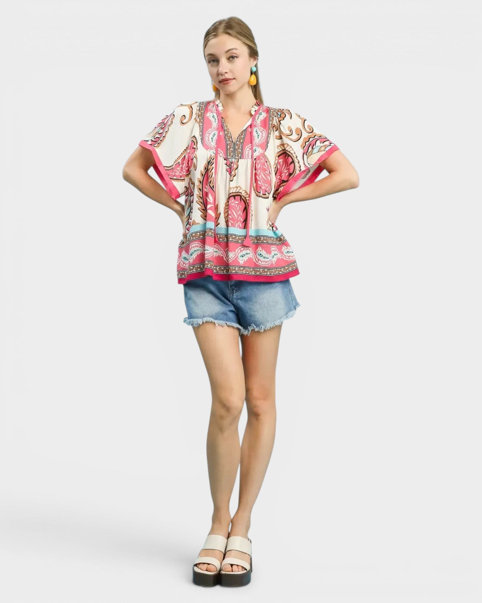 Beach Rose Co. ivory rayon top with pink, tan, and blue paisley border print, split neckline, and tie detail.