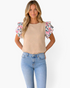 Beach Rose Co. parchment textured top with multicolor floral ruffle sleeves worn by a blonde model with blue jeans.