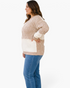 Beach Rose Co. plus size cream and taupe patchwork cable knit V-neck sweater worn by a model in profile view.