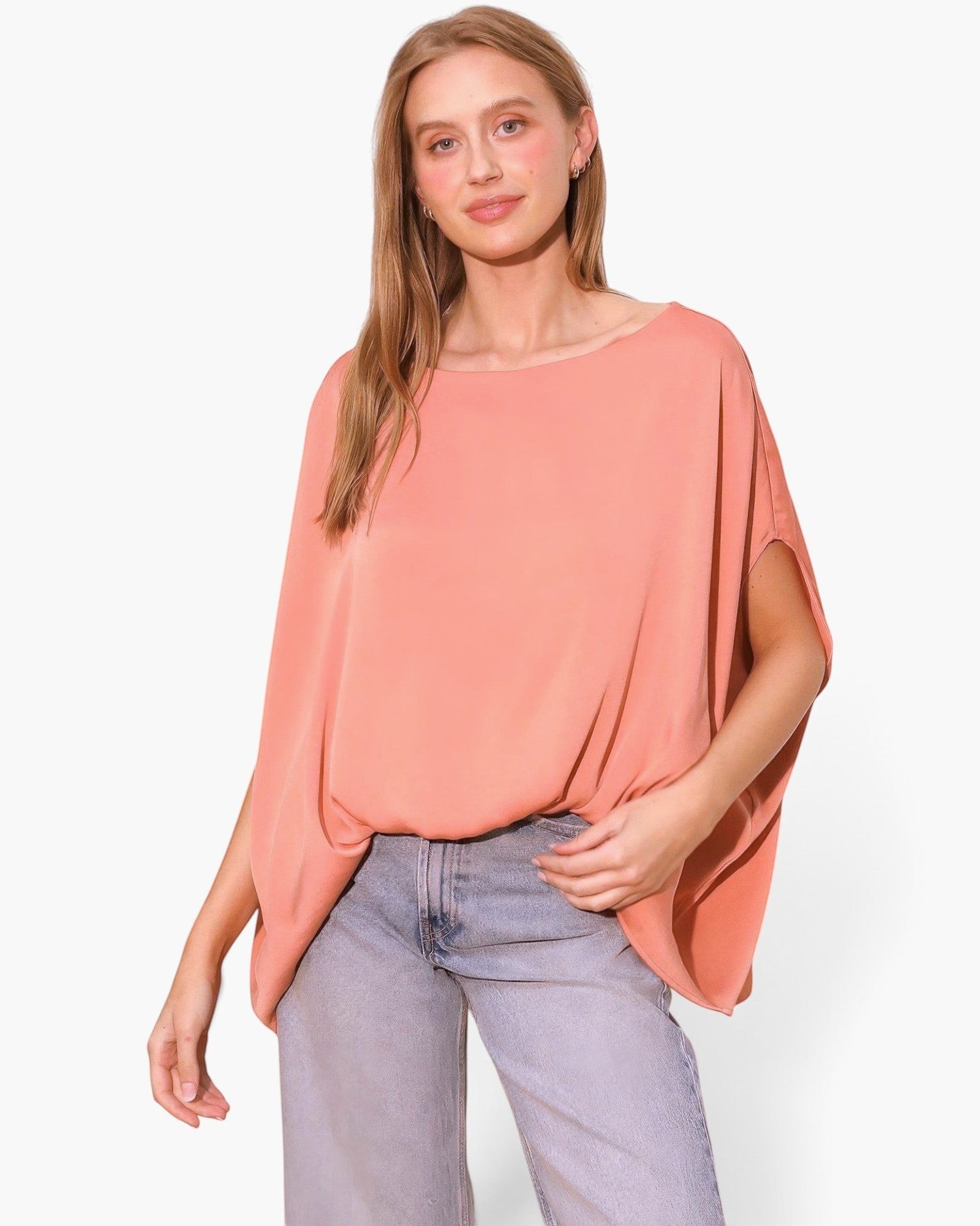 Beach Rose Co. peach washed poly silk boat neck caftan top with flowy sleeves worn by a model with light blue jeans