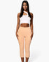 Beach Rose Co. peach cropped pants with slit hem detail worn by a model with a white asymmetrical crop top