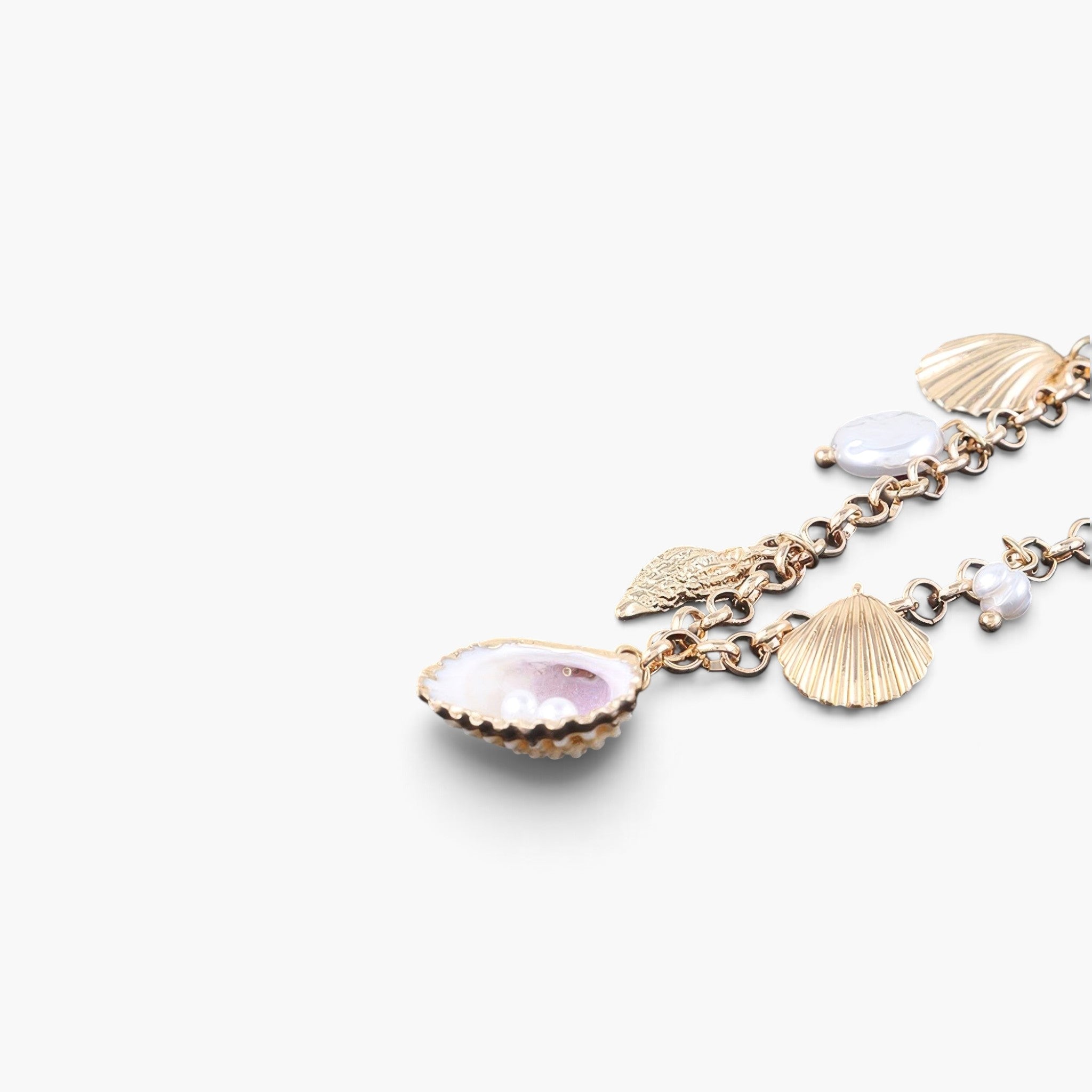Beach Rose Co. gold chain necklace featuring delicate pearl and shell charms for a coastal-inspired look.