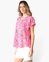 Beach Rose Co. pink V-neck top with multicolor abstract animal print, cuffed short sleeves, and a relaxed drape.