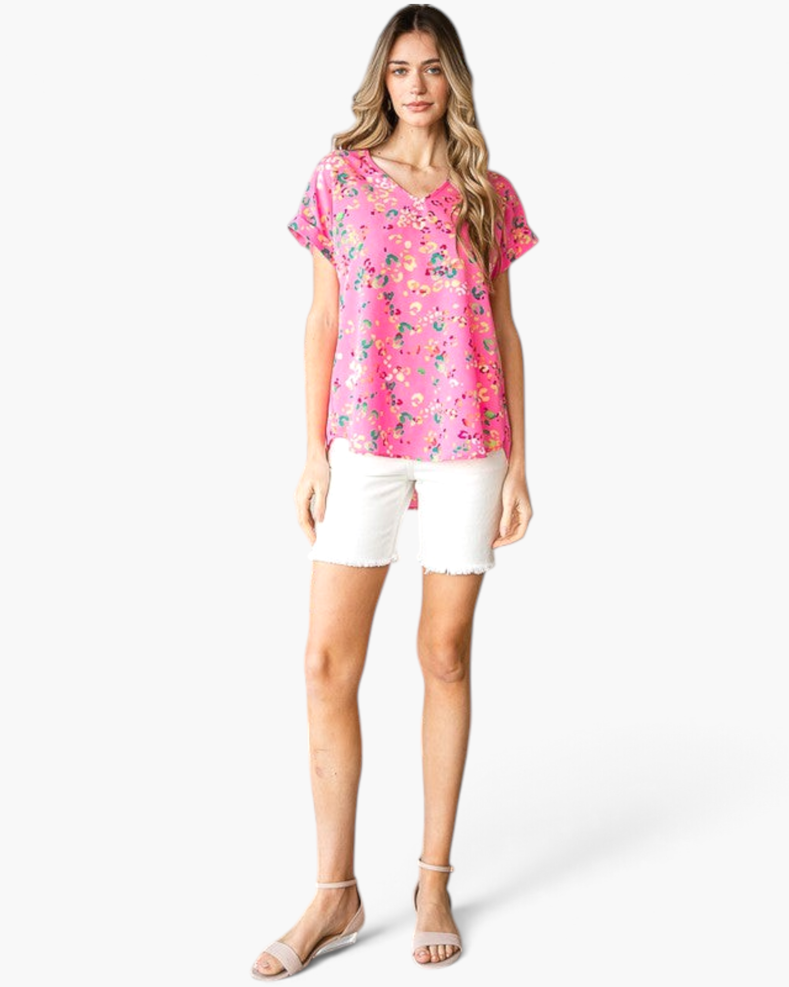 Beach Rose Co. pink V-neck top with abstract animal print, cuffed short sleeves, and curved hem worn with white shorts