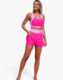 Beach Rose Co. two-piece bikini in vibrant pink color block with high-waisted skirted bottoms and tie-up details.