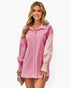 Beach Rose Co. pink color block button down blouse with long cuffed sleeves worn by a smiling woman