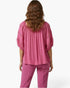 Beach Rose Co. pink short sleeve blouse with crochet sleeve detail and scoop neckline worn by a woman from behind