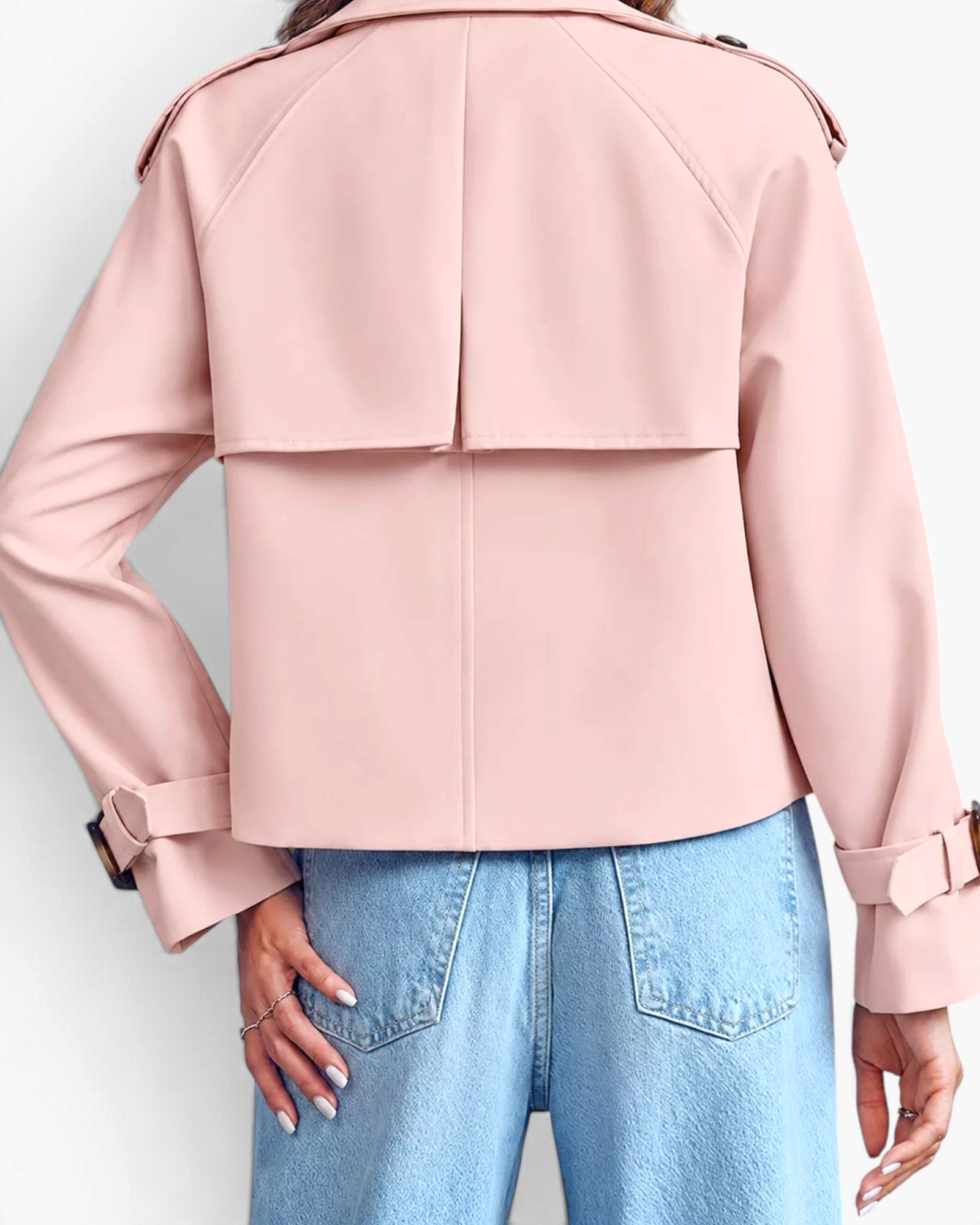 Beach Rose Co. light pink cropped trench jacket with back storm flap and buckled cuffs worn with blue jeans