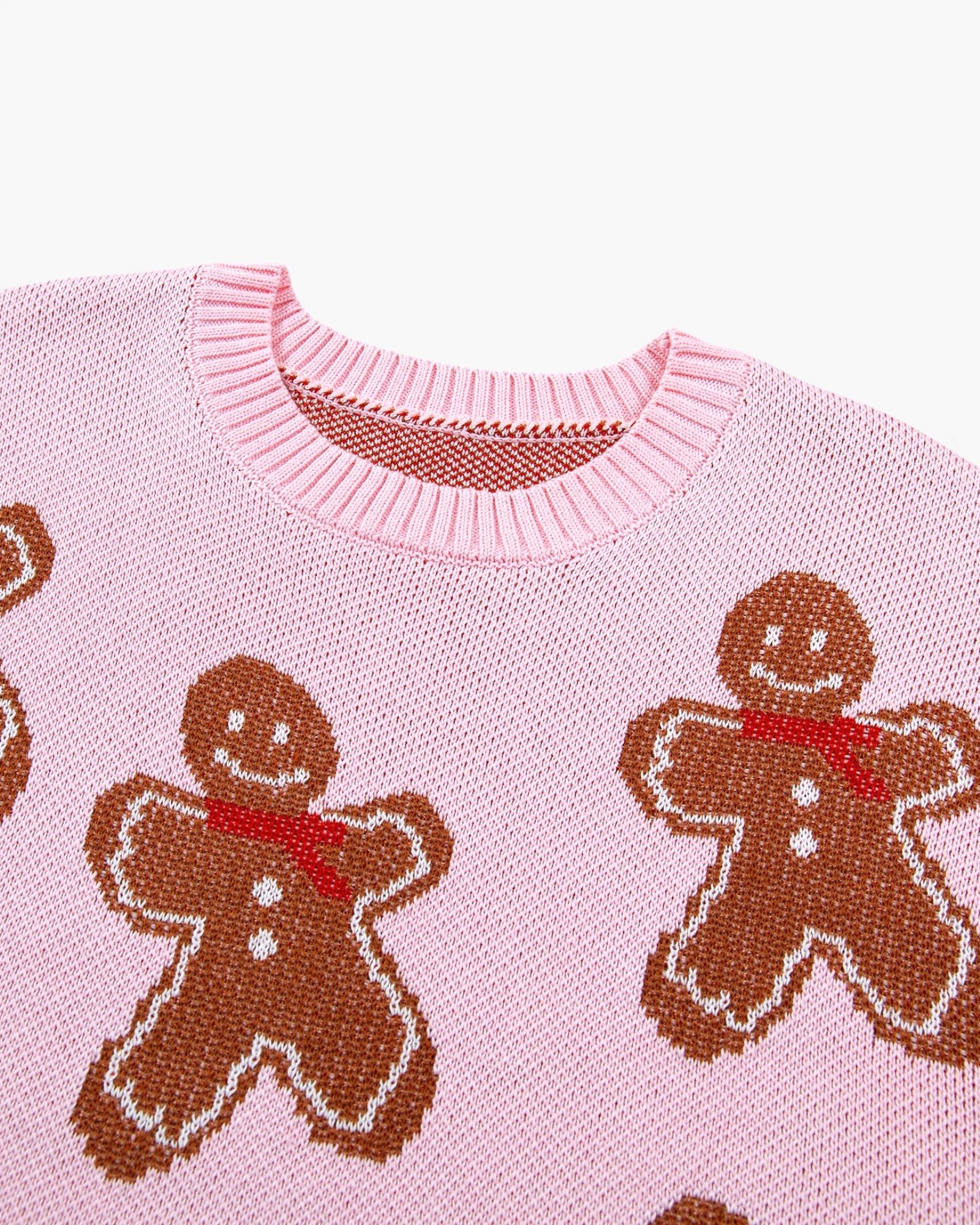 Beach Rose Co. pink knit crewneck sweater featuring an allover pattern of brown gingerbread men with red scarves.