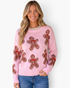 Beach Rose Co. pink crewneck sweater featuring an allover brown gingerbread man pattern with red scarf details.