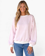 Beach Rose Co. pink and white gingham sweatshirt with balloon sleeves and white ribbed trim worn by a smiling model.