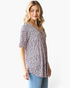 Beach Rose Co. pink leopard print babydoll top with a crisscross V-neckline and short sleeves on a blonde model