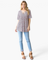 Beach Rose Co. pink leopard print babydoll top with a crisscross V-neckline worn with light wash jeans and sandals.