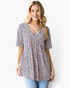 Beach Rose Co. pink leopard print babydoll top with a crisscross V-neckline worn by a smiling blonde model.
