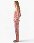 Beach Rose Co. pink leopard print pajama set with polka dot cuffs and piping worn by a woman in profile view
