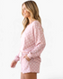 Beach Rose Co. dusty pink polka dot long sleeve lounge set with matching drawstring shorts on a smiling model