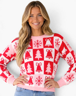 Beach Rose Co. pink and red Christmas checkerboard sweater with tree, bell, and snowflake motifs and ribbed trim.