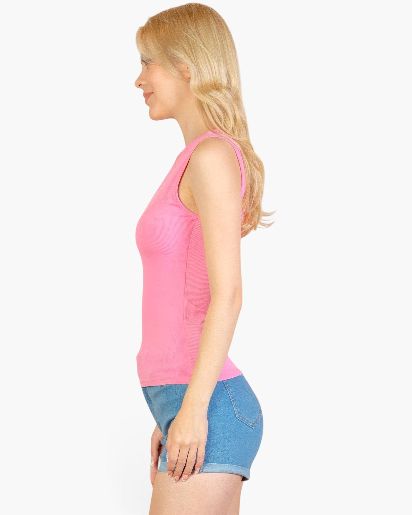 Beach Rose Co. pink ribbed V-neck sleeveless top worn by a blonde woman in profile view with blue denim shorts