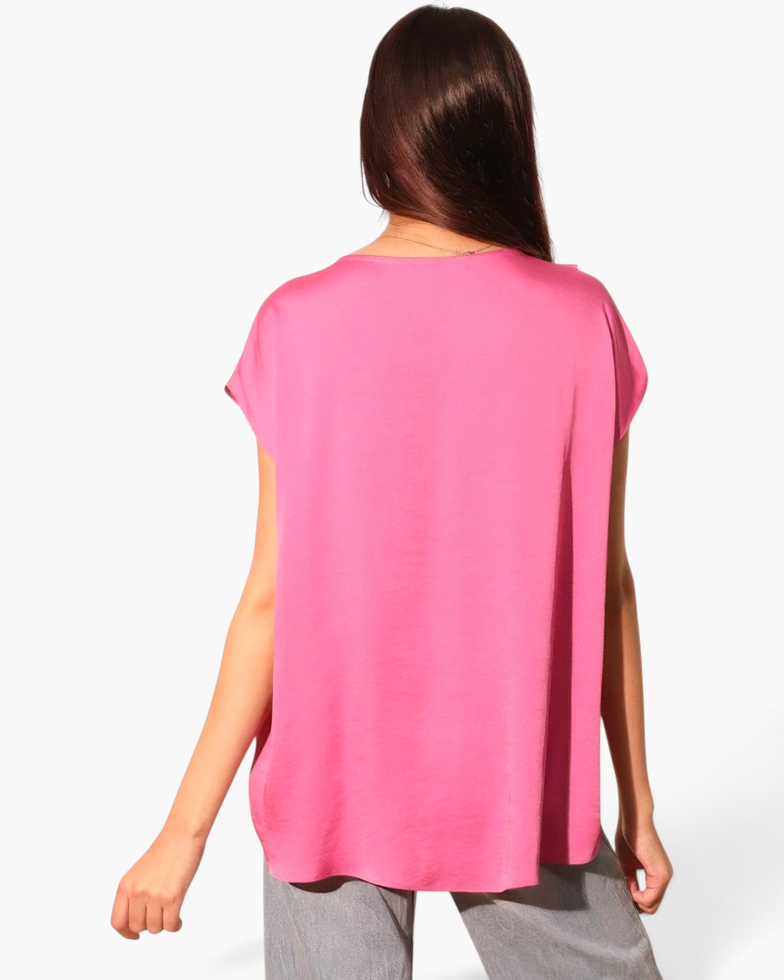 Beach Rose Co. pink washed poly silk tunic top with a relaxed fit and tulip hemline, back view on a model.