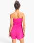 Back view of a model wearing a Beach Rose Co. hot pink strapless romper with shirred waist and relaxed shorts