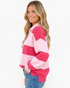 Beach Rose Co. model wearing a pink and fuchsia striped half-zip sweater with balloon sleeves and a ribbed collar.