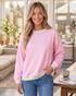 Beach Rose Co. pink sweatshirt with green and white striped trim, dropped shoulders, and relaxed fit on a woman.