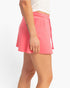 Side view of a model wearing a Beach Rose Co. pink wrap front skort with an elastic drawstring waist.