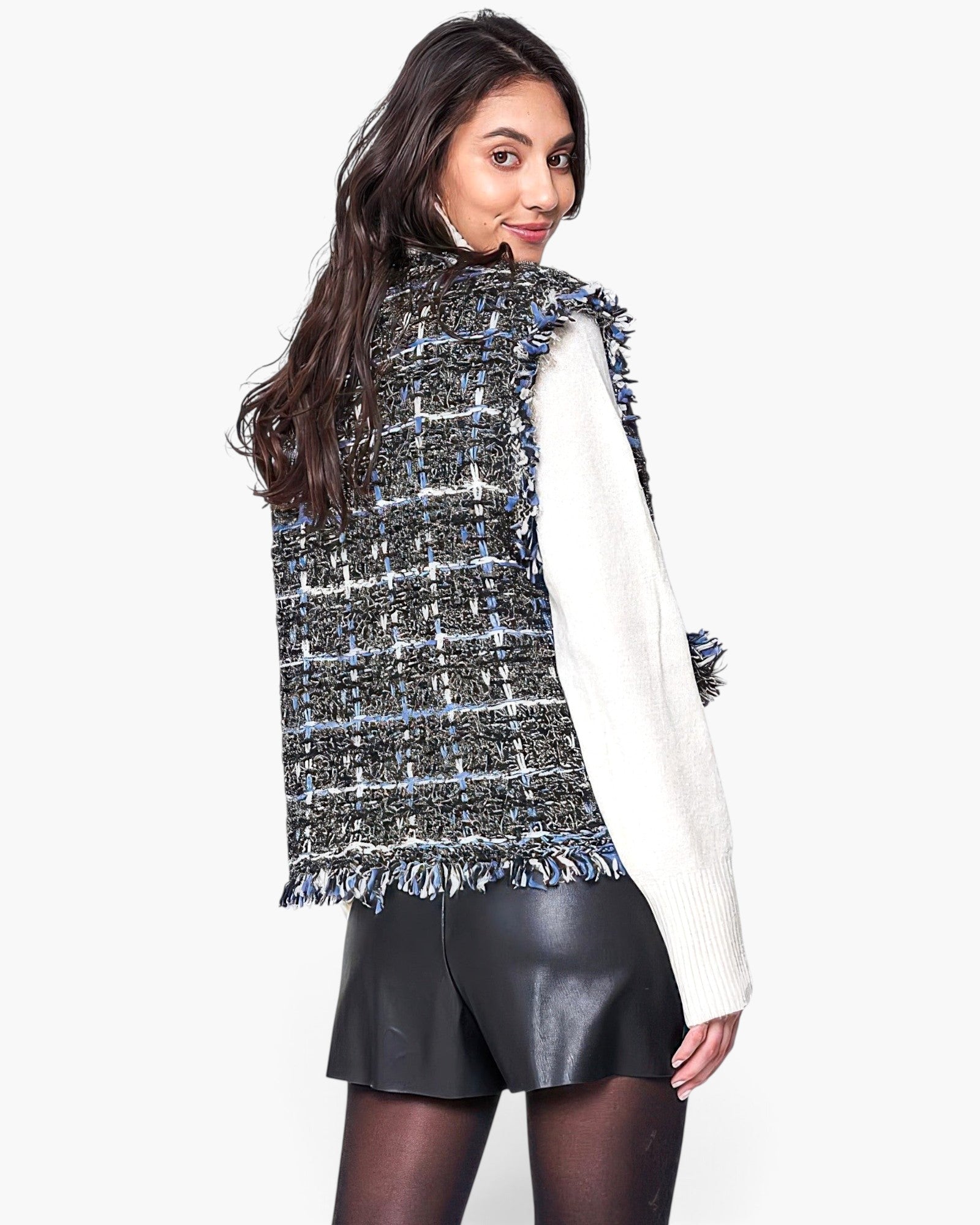 Beach Rose Co. plaid tweed vest with frayed edges worn over a white sweater and black skirt, back view.