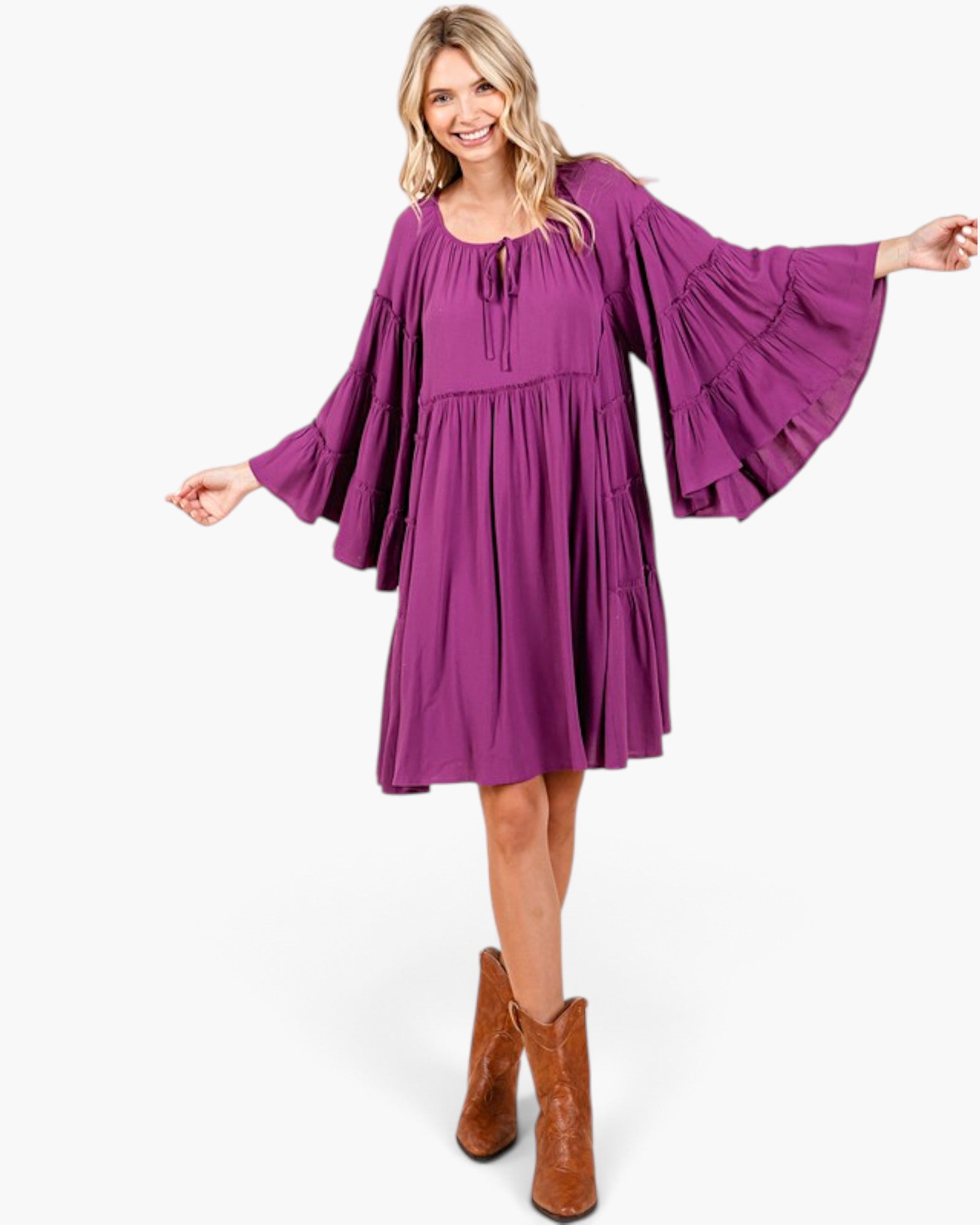 Beach Rose Co. plum babydoll dress with tiered bell sleeves, gathered neckline, and tie detail on a smiling model.