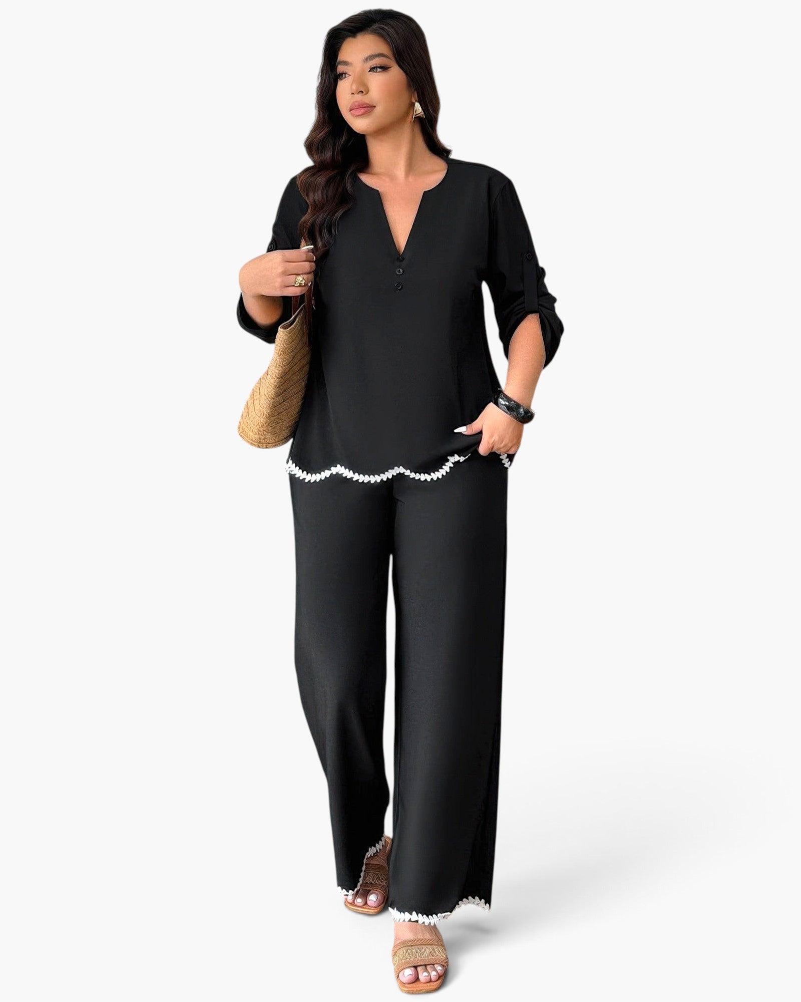 Beach Rose Co. plus size black two-piece set with white ruffle trim, v-neck top, and wide-leg trousers on a model.