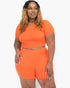 Beach Rose Co. plus size orange short sleeve crop top and matching shorts set on a model with long wavy hair.
