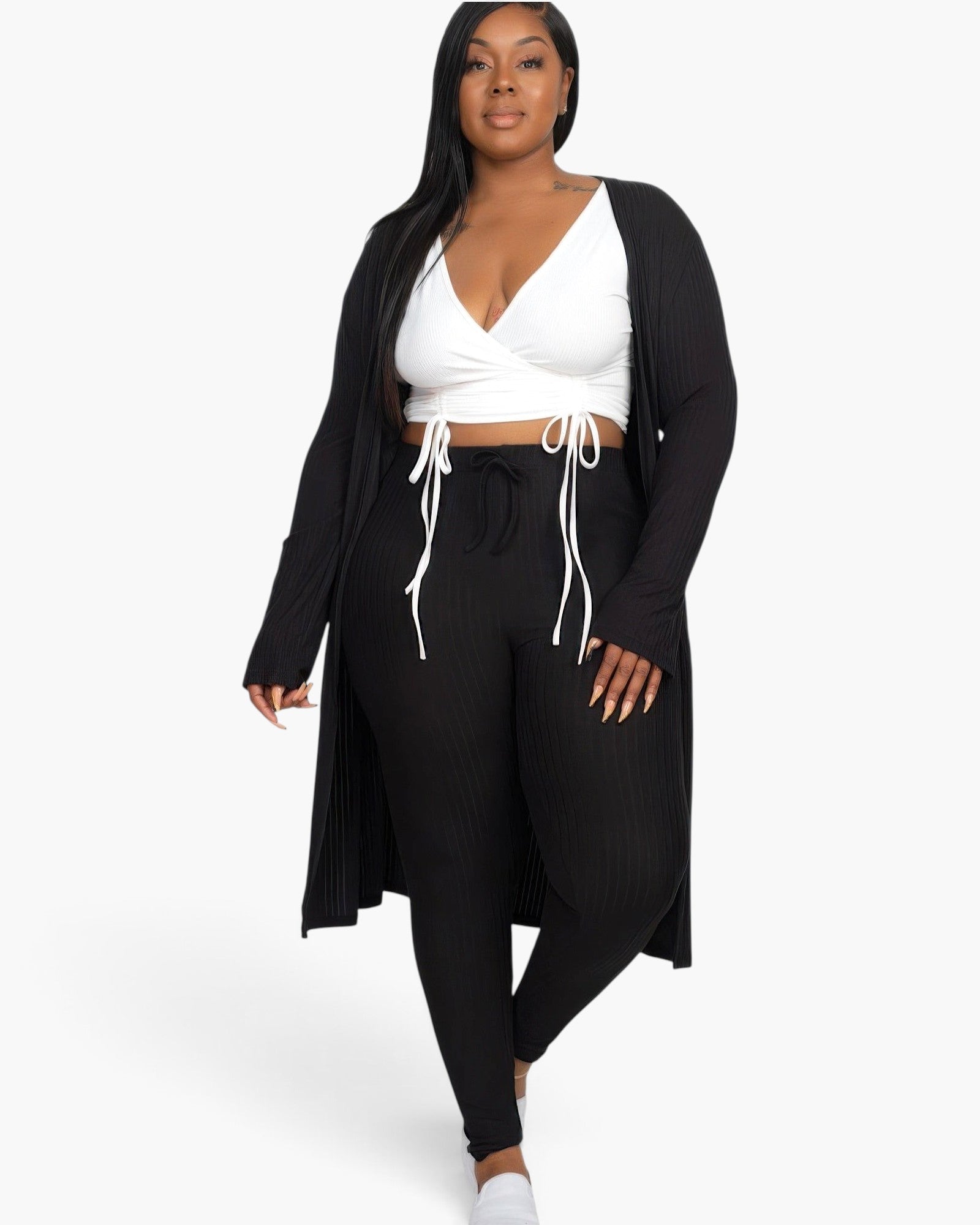 Beach Rose Co. plus size model wearing a black ribbed long cardigan and matching leggings with a white crop top