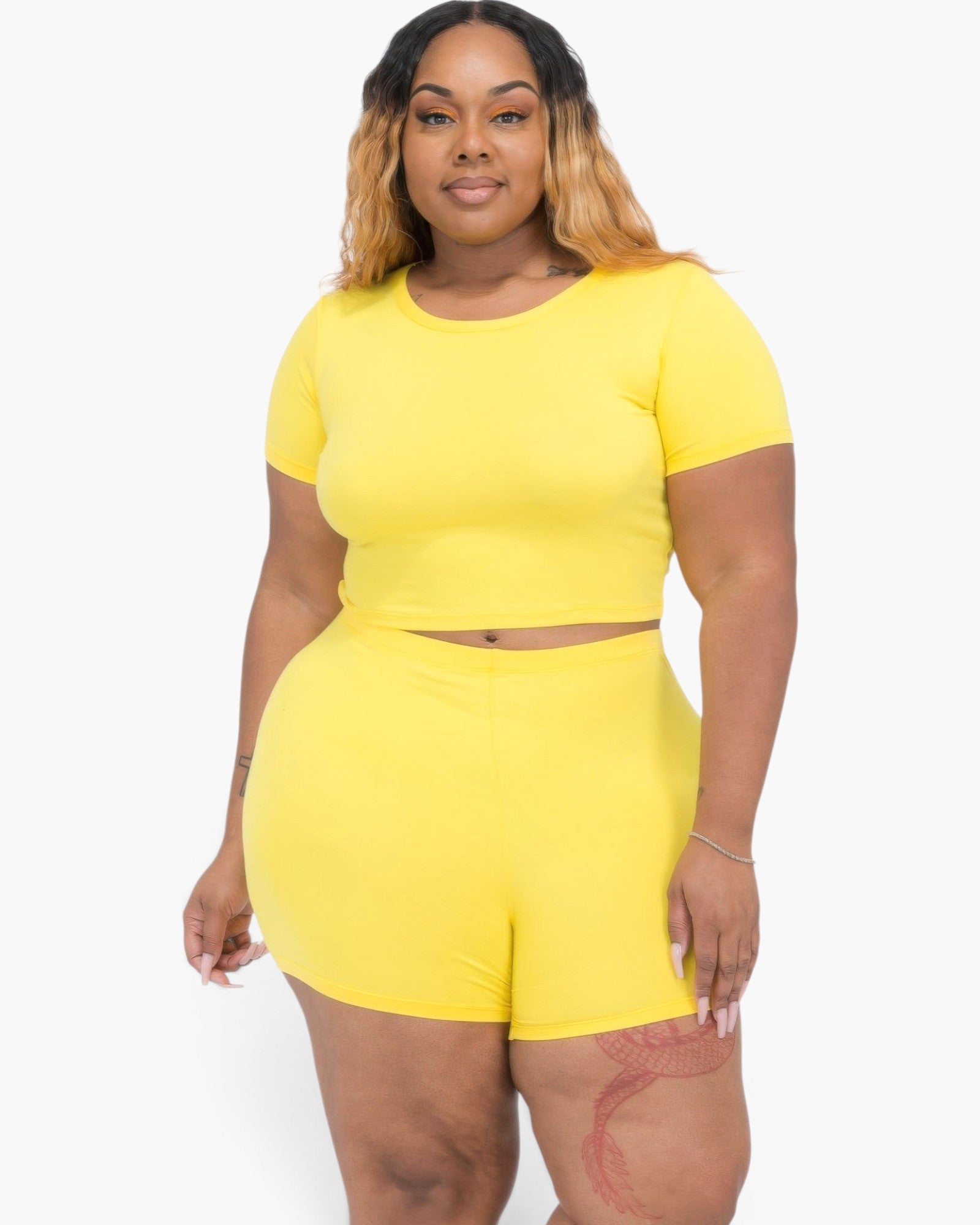 Beach Rose Co. plus size yellow short sleeve crop top and shorts set on a model with long blonde highlighted hair.