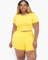 Beach Rose Co. plus size yellow short sleeve crop top and shorts set on a model with long blonde highlighted hair.