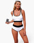 Beach Rose Co. white polka-dot bikini set with black contrast trim, scoop-neck top, and high-waisted bottoms.