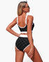 Beach Rose Co. black and white polka-dot high-waisted bikini set with contrast trim worn by a model from the back.
