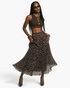 Beach Rose Co. model wearing a brown polka dot pleated maxi skirt with an elastic waistband and a brown crop top.