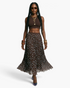 Beach Rose Co. brown polka dot pleated maxi skirt with an elastic waistband worn by a model with a brown crop top.
