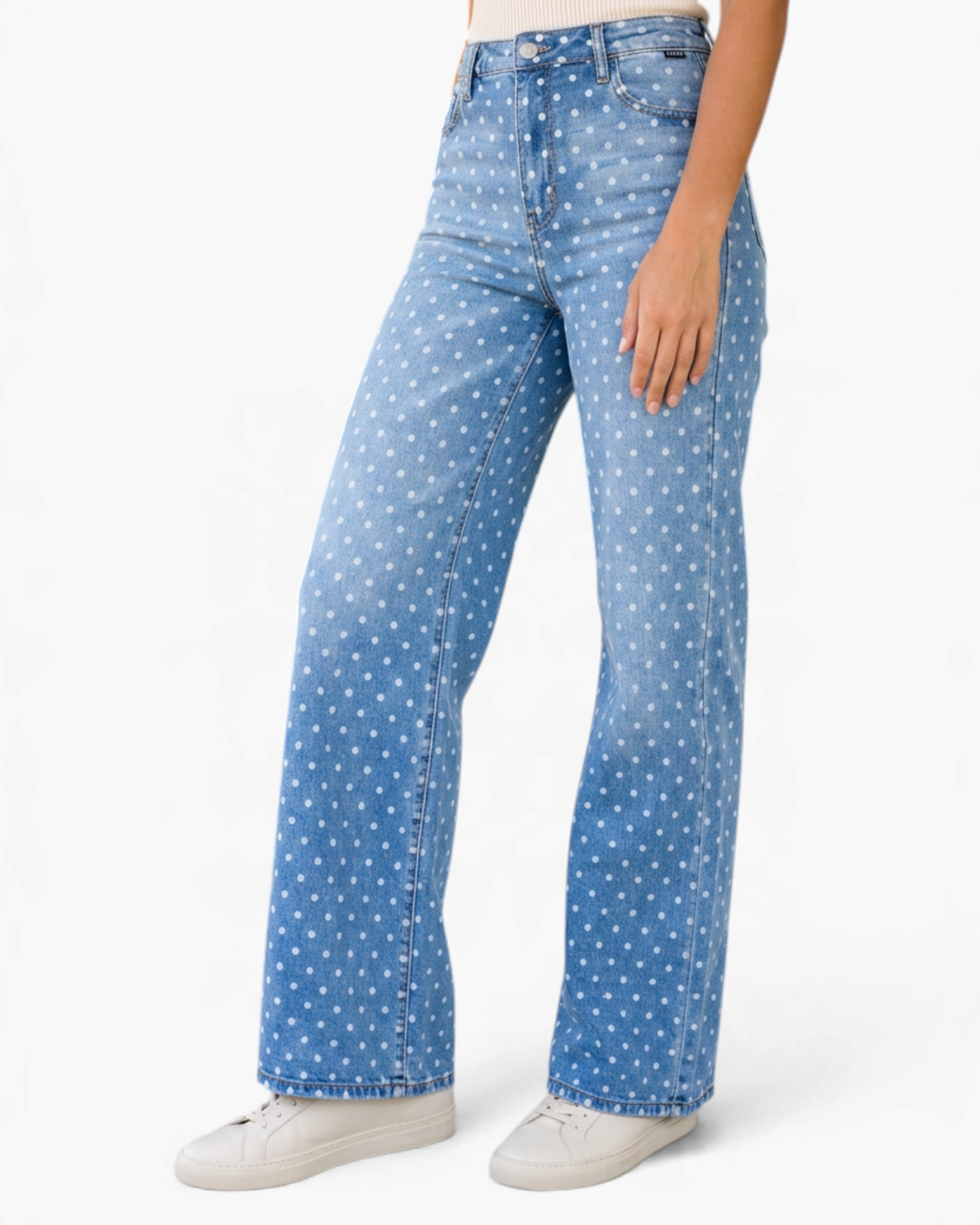 Beach Rose Co. light wash wide leg jeans featuring a white polka dot print, worn with white sneakers.