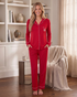 Beach Rose Co. red pajama set with button-front top, chest pocket bow, and white piping on a smiling woman.
