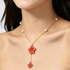Beach Rose Co. 18K gold-plated Y-necklace featuring two red resin flowers and white faux pearl accents on a fine chain.