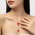 Beach Rose Co. Y-shaped 18K gold-plated necklace featuring two red resin flowers and white faux pearl accents.