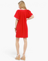 Beach Rose Co. red linen-cotton mini dress with flutter sleeves and white striped trim, back view on a model.