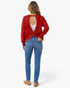 Beach Rose Co. deep red sweatshirt with an open-back twisted design worn over a white lace bralette with blue jeans.