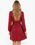 Back view of a Beach Rose Co. red plaid mini dress with long sleeves and a smocked waist on a blonde model.