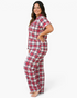 A smiling model wearing a Beach Rose Co. plus size red plaid pajama set with short sleeves and full-length pants.